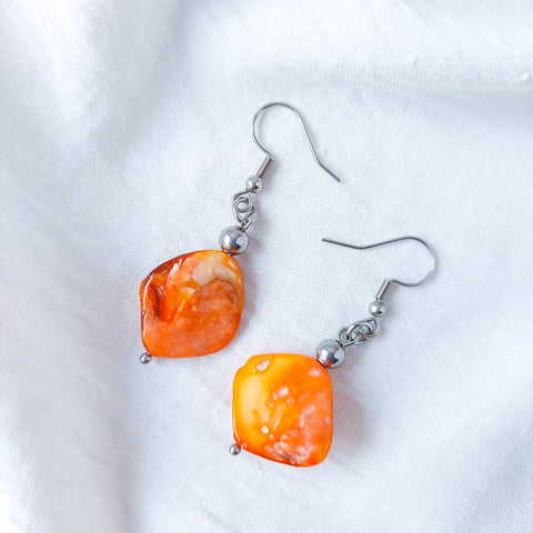 Handmade orange mother of pearl dangle drop earrings with stainless steel and hypoallergenic hooks.