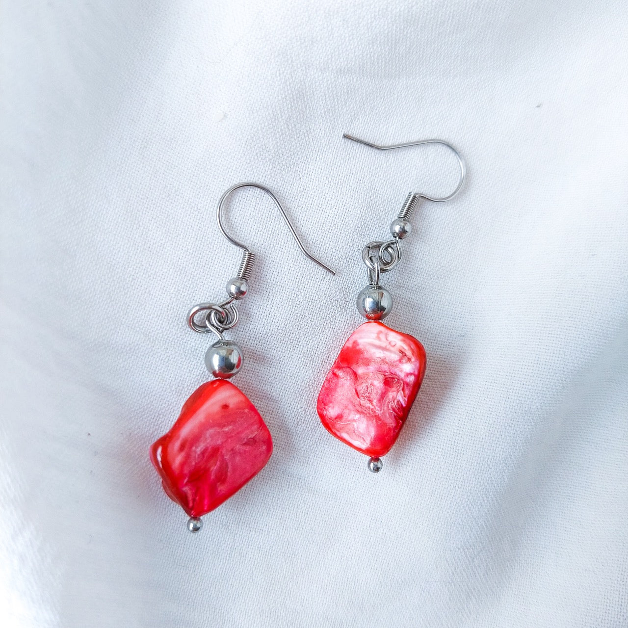 Handmade red mother of pearl dangle drop earrings with stainless steel and hypoallergenic hooks.