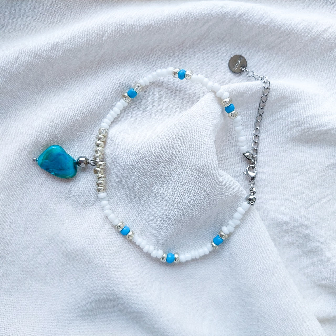 Handmade mother of pearl beaded anklet. With a blue mother of pearl pendant and acrylic beads, nylon thread and stainless steal beads and hook.